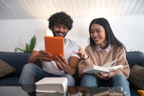 Studying together. Two young people sitting on the sofa and studying