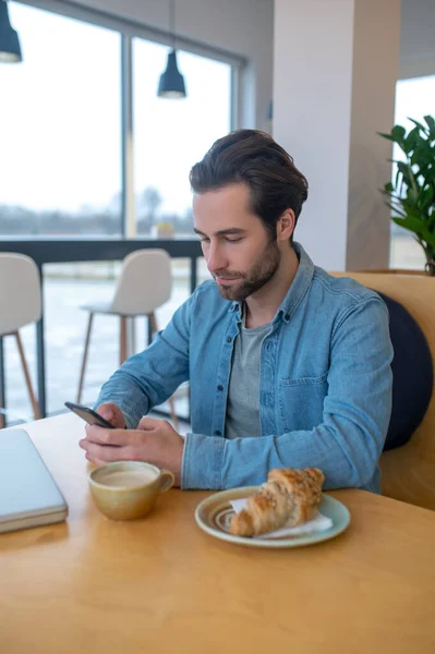 Message Focused Bearded Young Man Looking Attentively Smartphone Sitting Table — Stock Photo, Image