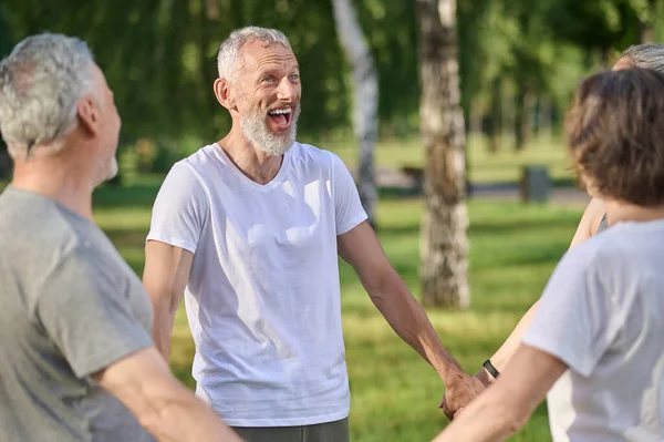 Parkta. Bir grup insan güneşli bir günde parkta iyi vakit geçiriyor.