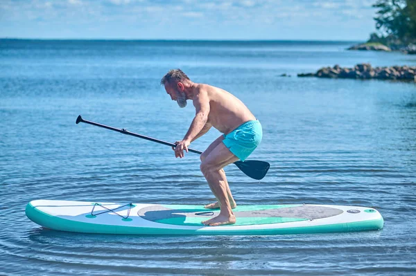 Jämvikt Koncentrerad Man Med Åra Handen Sidled Till Kamera Balansering — Stockfoto