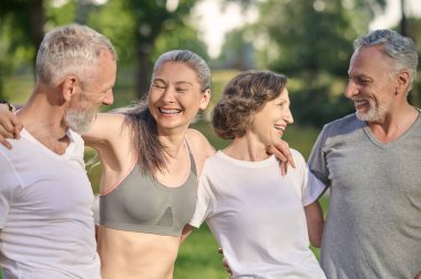 Parkta spor. Parkta birlikte vakit geçiren ve mutlu görünen bir grup insan.