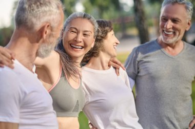 Parkta spor. Parkta birlikte vakit geçiren ve mutlu görünen bir grup insan.