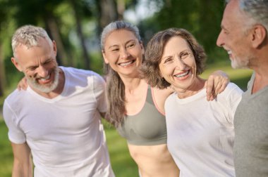 Parkta spor. Parkta birlikte vakit geçiren ve mutlu görünen bir grup insan.