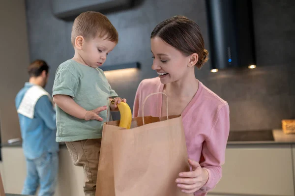 食べ物だ 若いですお母さんで小さな子供オープンバッグで食べ物でキッチン — ストック写真