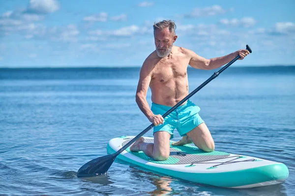 Aviron Planche Pagaie Homme Concentré Barbu Aux Cheveux Gris Agenouillé — Photo