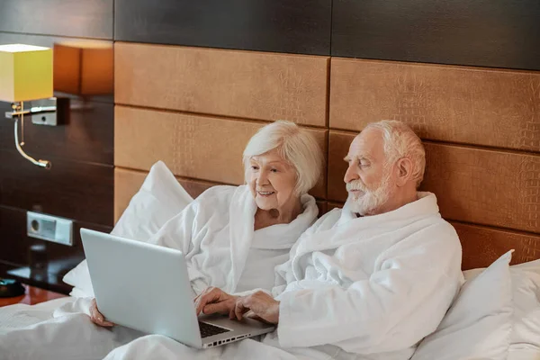 Interesting video. Two seniors watching something on laptop and looking interested