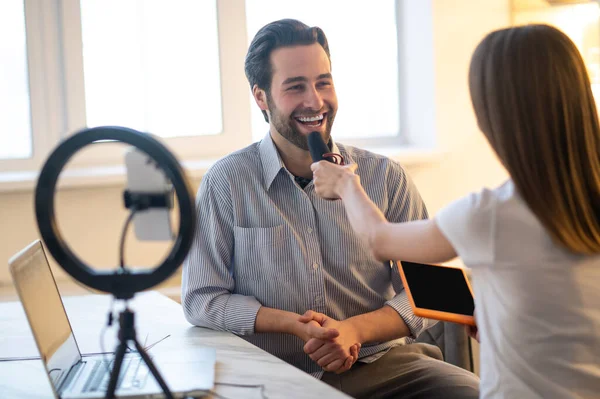 Entrevista Mujer Pelo Largo Sosteniendo Micrófono Mientras Hombre Barbudo Sonriente — Foto de Stock