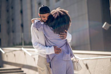 Romantizm. Genç çift dışarıda sarılıyor ve heyecanlı görünüyorlar.