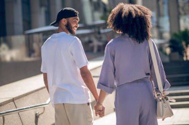 El ele. Sokakta yürüyen ve el ele tutuşan bir çift.