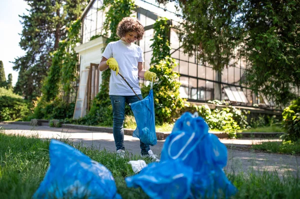 Eco Volunteer Curly Haired Teen Gathering Garbage Looking Involved — Fotografia de Stock