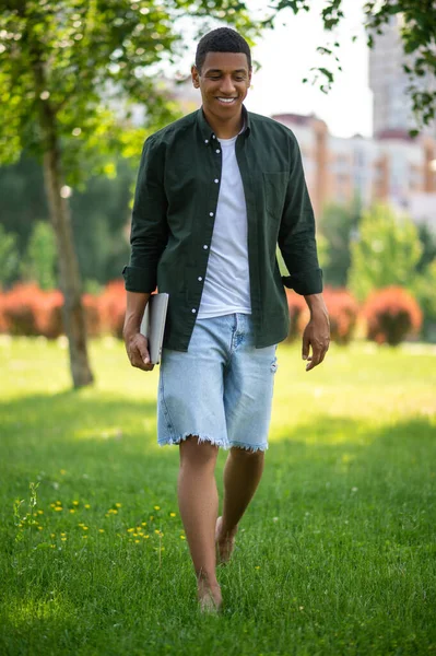 Camina Joven Sonriente Hombre Piel Oscura Con Portátil Caminando Descalzo — Foto de Stock