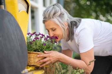 Bahçıvanlık. Beyaz elbiseli bir kadın Graden 'da vakit geçiriyor ve meşgul görünüyor.