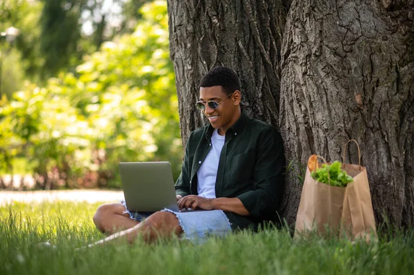 Good Mood Dark Skinned Guy Sunglasses Smiling Typing Laptop Sitting — 图库照片