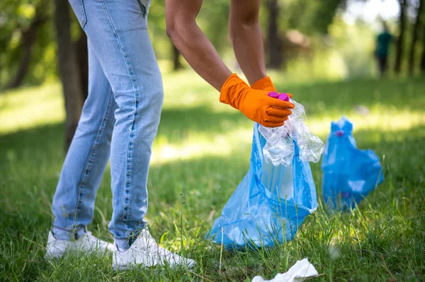 Czyszczenie Natura Nogi Ręce Człowieka Zbierającego Plastikowe Śmieci Torbie Zielonym — Zdjęcie stockowe