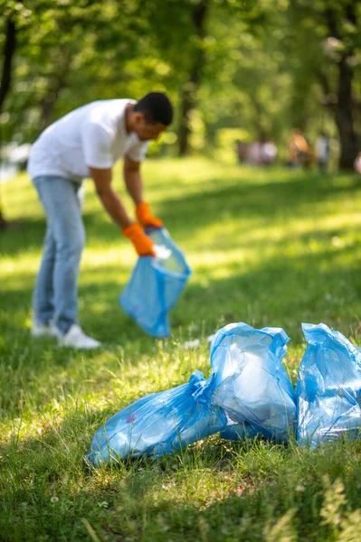 Cleaning Young Dark Skinned Guy Gloves Standing Bent Putting Waste — Foto Stock