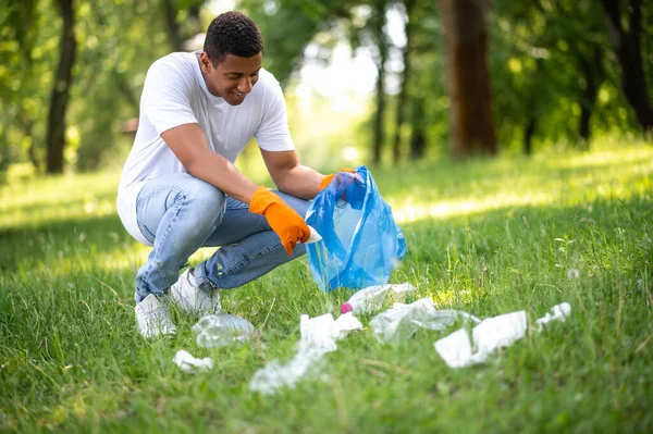 Cleaning Nature Young Adult Dark Skinned Man Gloves Crouched Bagging — Stok Foto