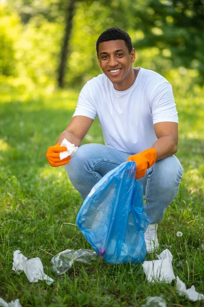 Good Mood Dark Skinned Man Wearing Gloves Crouched Picking Paper —  Fotos de Stock