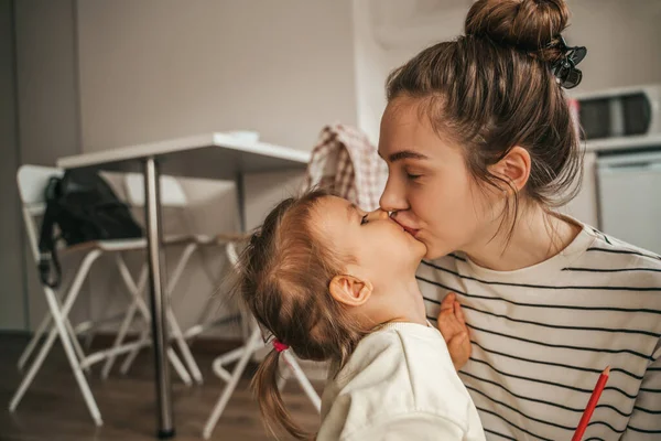 Loving Beautiful Young Female Parent Giving Tender Kiss Her Child — 图库照片