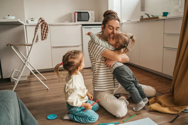 Little Girl Sitting Kitchen Floor Looking Her Female Parent Kissing — Stock Fotó