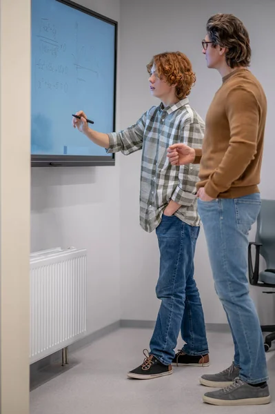 Maths Lesson Ginger Boy Writing Board Teacher Standing Next Him — Stockfoto
