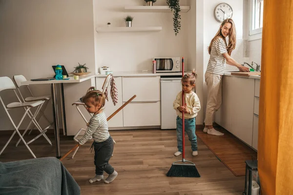 Smiling Happy Young Mother Washing Dishes Watching Her Children Sweeping —  Fotos de Stock