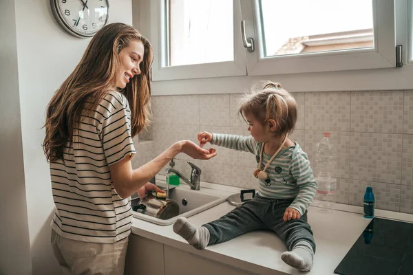 Little Girl Sitting Kitchen Sink Helping Her Happy Young Mother — Stock Photo, Image