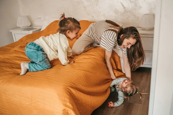 Усміхнена Радісна Молода Жінка Сидить Ліжку Компанії Своїх Двох Дітей — стокове фото