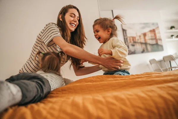 Smiling Cheerful Young Female Parent Sitting Bed Company Her Daughters — Stockfoto