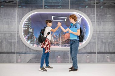 El sıkışalım. İki çocuk el sıkışıyor ve neşeli görünüyor.