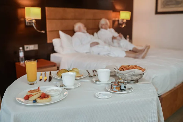 Breakfast Time Senior Couple White Robes Hotel Room Breakfast — 스톡 사진
