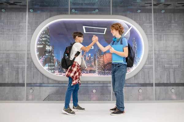 El sıkışalım. İki çocuk el sıkışıyor ve neşeli görünüyor.