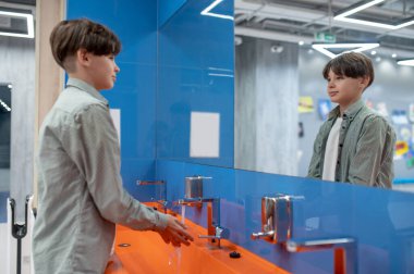 Washing hands. A boy washing hands in a school toilet