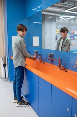 Washing hands. A boy washing hands in a school toilet