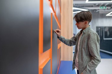School corridor. A school boy standing near lockers in the corridor