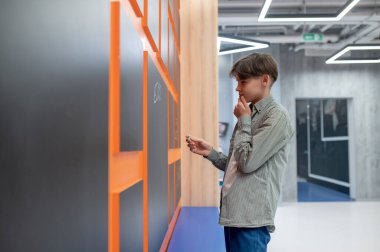 School corridor. A school boy standing near lockers in the corridor