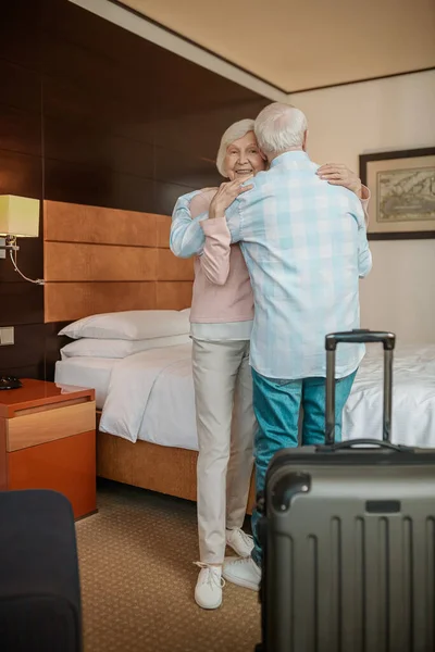 Happy couple. Gray-haired couple embracing and feeling happy