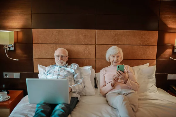 Online Senior Couple Lying Bed Gadgets Hands — Stok fotoğraf