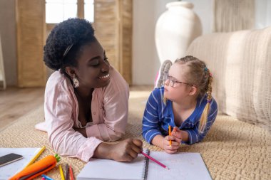At the lesson. A girl in eyeglasses looking at her teacher while studying at home