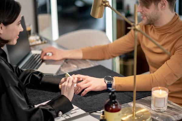 Manicure. Young man having manicure in a beauty salon