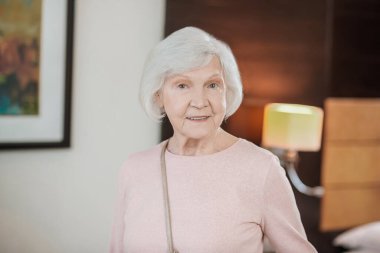 Senior lady. Short-haired elegant senior lady in a hotel room