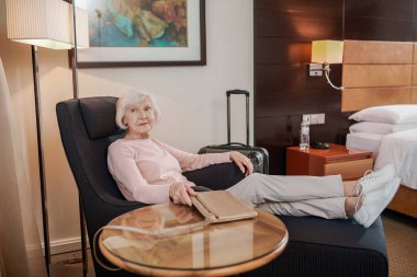 Senior lady. Short-haired elegant senior lady in a hotel room