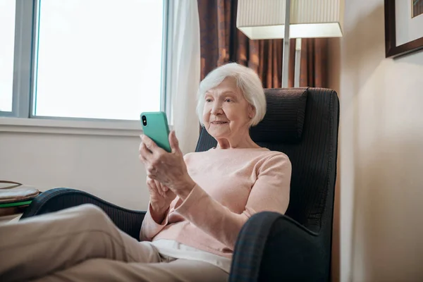 Online Pleasant Looking Senior Lady Texting Looking Involved — ストック写真