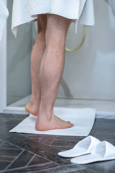 In the shower. Close up picture of mans legs in the showe