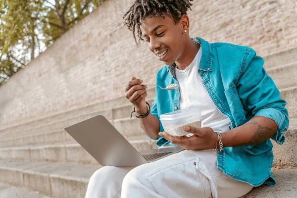 Γεύμα Σκούρο Δέρμα Κομψό Τύπο Χαμογελώντας Κοιτάζοντας Οθόνη Laptop Τρώει — Φωτογραφία Αρχείου