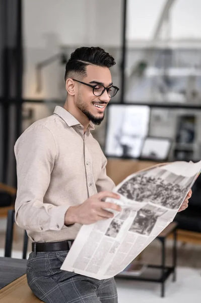 Positive Information Cheerful Young Bearded Man Glasses Looking Newspaper Standing — Stock fotografie