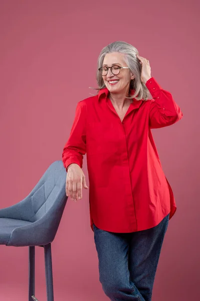 Studio Mature Woman Red Shirt Eyeglasses Standing Chair — Fotografia de Stock