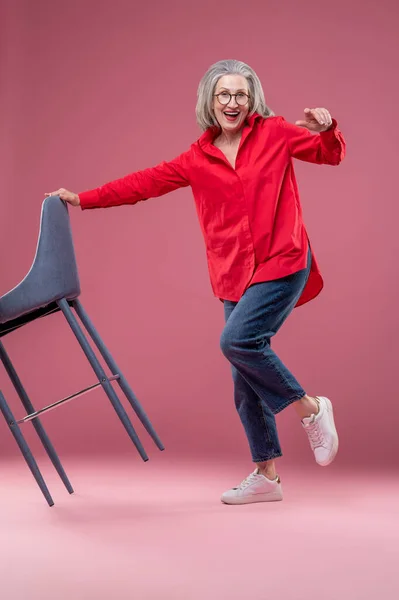 Active woman. Active mature woman in a red shirt in a studio