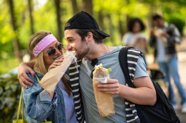 Weekend. Young people eating sandwiches and having fun