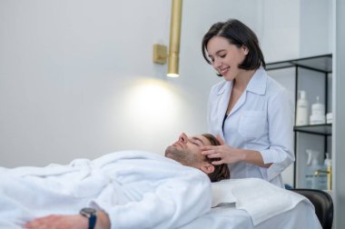Face care. Young male client having face massage in a professional salon