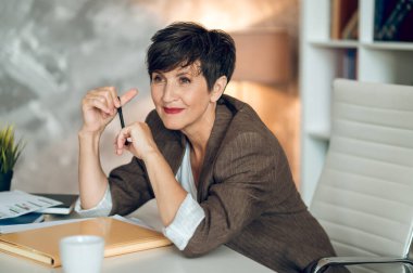 Good-looking businesswoman. Pretty mature woman smiling nicely and looking positive